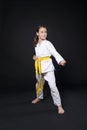 Child girl in karate suit with yellow belt show stance Royalty Free Stock Photo