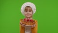 Child girl kid dressed as professional cook chef baker with tasty strawberry pie on chroma key Royalty Free Stock Photo