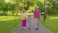 Child girl kid walking with senior grandmother and grandfather family holding hands in summer park Royalty Free Stock Photo