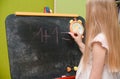 Child girl learning to write on drawing board at home Royalty Free Stock Photo