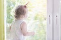 Child girl looking out window. Kid looks out window Royalty Free Stock Photo