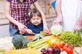 Child girl with mother and father cooking together