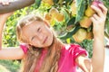 Child (girl) is near apple tree.