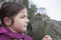 Child girl observing little wild flower