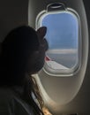 Child girl observing the sky from the window of an aircarft Royalty Free Stock Photo