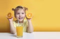 Child girl with oranges, caucasian little girl drinking orange juice. Toddler kid have a mealof fresh fruits Royalty Free Stock Photo