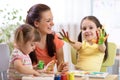 Child girl with painted hands. Kids drawing and coloring with teacher in daycare center. Royalty Free Stock Photo