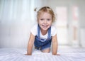 Child girl playing on a bed.Happy smiling girl indoors.Caucasian kid in bedroom Royalty Free Stock Photo