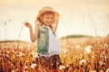 Child girl playing with blow balls on summer field