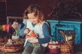 Child girl playing with easter eggs and handmade decorations in cozy country house