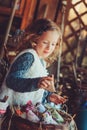 Child girl playing with easter eggs and handmade decorations in cozy country house