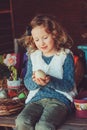 Child girl playing with easter eggs and handmade decorations in cozy country house