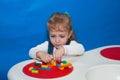 A child concentrates constructing a house from a designer