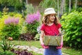 Child girl playing little gardener and helping in summer garden, Royalty Free Stock Photo