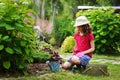 Child girl playing little gardener and helping in summer garden Royalty Free Stock Photo