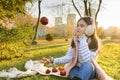 Child girl playing with red apples in sunny autumn park Royalty Free Stock Photo