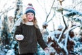 Child girl playing with snow in winter garden or forest, making snowballs and blowing snowflakes Royalty Free Stock Photo