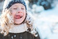 Child girl playing with snow in winter garden or forest, making snowballs and blowing snowflakes Royalty Free Stock Photo