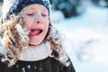 Child girl playing with snow in winter garden or forest, making snowballs and blowing snowflakes Royalty Free Stock Photo