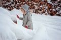 Child girl plays with snow on the walk in snowy winter Royalty Free Stock Photo