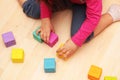 Child girl plays with toys at home, in kindergarten or nursery. Little girl plays with colored cubes at home