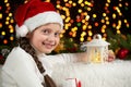 Child girl portrait with christmas decoration, dark background with lights, face expression and happy emotions, dressed in santa h Royalty Free Stock Photo