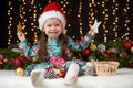 Child girl portrait in christmas decoration, happy emotions, winter holiday concept, dark background with illumination and boke li Royalty Free Stock Photo