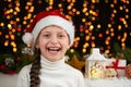 Child girl portrait in santa hat with christmas decoration, dark background with lights, face expression and happy emotions, winte Royalty Free Stock Photo