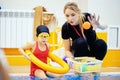 Child girl is practicing swimming in pink bathing suit in pool, coach will conduct training swim Royalty Free Stock Photo