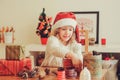 Child girl preparing gifts for christmas at home, cozy holiday interior