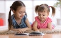 Child girl reading book with little sister at home Royalty Free Stock Photo