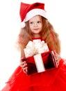 Child girl in red santa hat with gift box. Royalty Free Stock Photo
