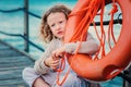 Child girl with rescue ring on wooden pier with sea background Royalty Free Stock Photo