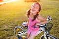 Child girl riding bicycle on summer sunset in the park. Royalty Free Stock Photo