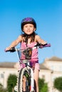 Child girl riding bicycle on summer sunset in the park. Royalty Free Stock Photo