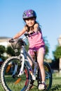 Child girl riding bicycle on summer sunset in the park. Royalty Free Stock Photo