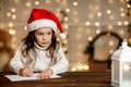 Child girl in santa hat writing letter to Santa Claus Royalty Free Stock Photo