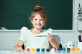 Child girl at school draws with paints. Kids artist creativity. Funny kids emotions. Royalty Free Stock Photo