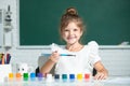 Child girl at school draws with paints. Kids artist creativity. Funny kids emotions. Royalty Free Stock Photo