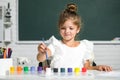 Child girl at school draws with paints. Kids artist creativity. Funny school girl face. Royalty Free Stock Photo