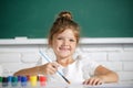 Child girl at school draws with paints. Kids artist creativity. Painting school lesson, drawing art. Royalty Free Stock Photo