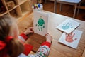 Child girl in seasonal sweater with handmade christmas handprints post cards