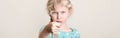 Child girl showing fig sign. Kid expressing strong negative emotion. Cute adorable blonde Caucasian preschool girl posing in