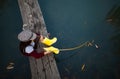 Child girl sits on wooden fishing bridge and catches fish with s Royalty Free Stock Photo