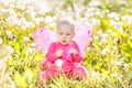 Child girl sitting among dandelions