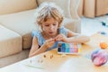 Child girl sitting on floor and sculpt from clay or plasticine at home.