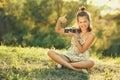 Child girl sitting on the grass. In her hands she has an old photo camera and she shows gesture all right Royalty Free Stock Photo