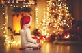 Child girl sitting back in front of Christmas tree on Christm Royalty Free Stock Photo
