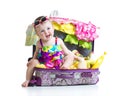 Child girl sitting in suitcase with things for Royalty Free Stock Photo