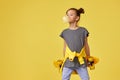 child girl with skateboard blowing a big bubble gum Royalty Free Stock Photo
